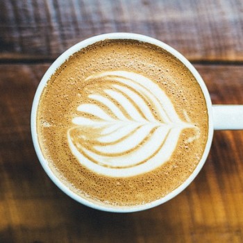 closeup of a leaf image drawn in the froth of a latte