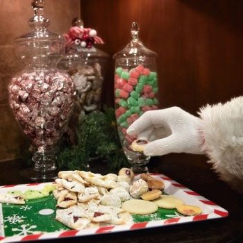 Santa indulging in holiday cookies and candy