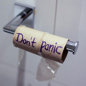 empty toilet paper roll with "Don't Panic" written on it